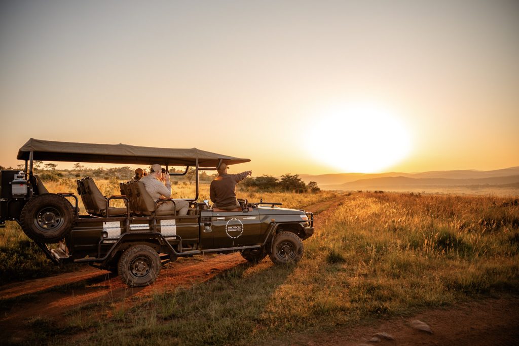 Mhondoro Safari Lodge and Villa, Luxurious Game drive vehicle with beautiful sunset.